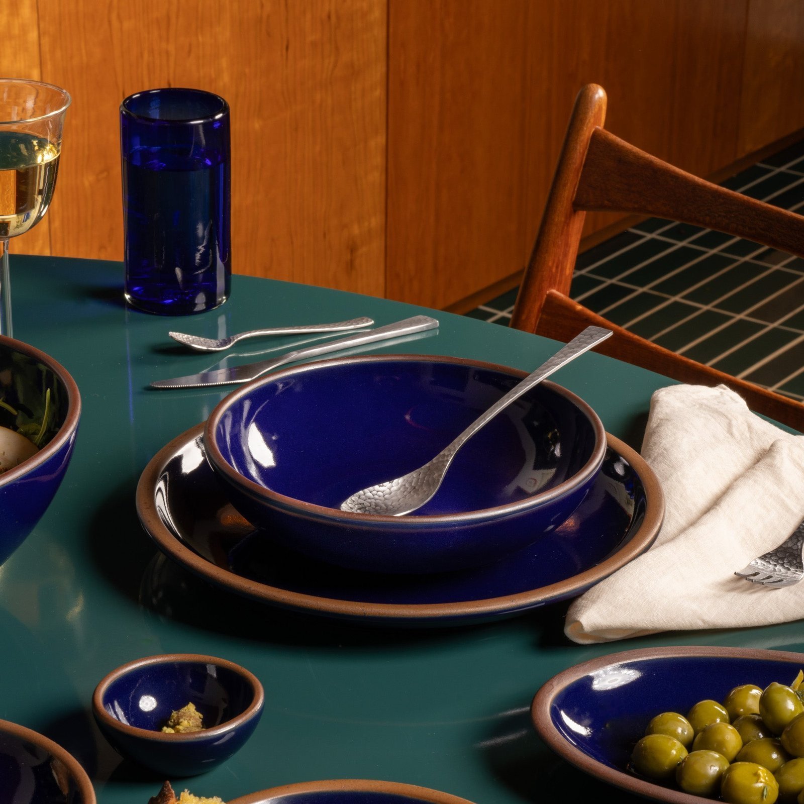 Vella Supply daily bowl in Midnight Navy, in a table setting with other dinnerware